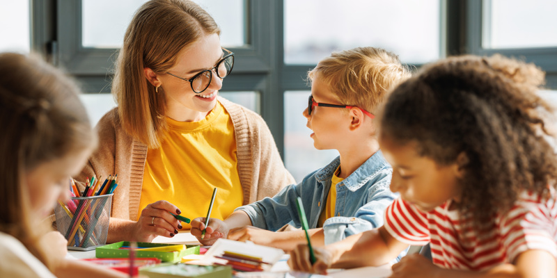 Teacher helping children with schoolwork