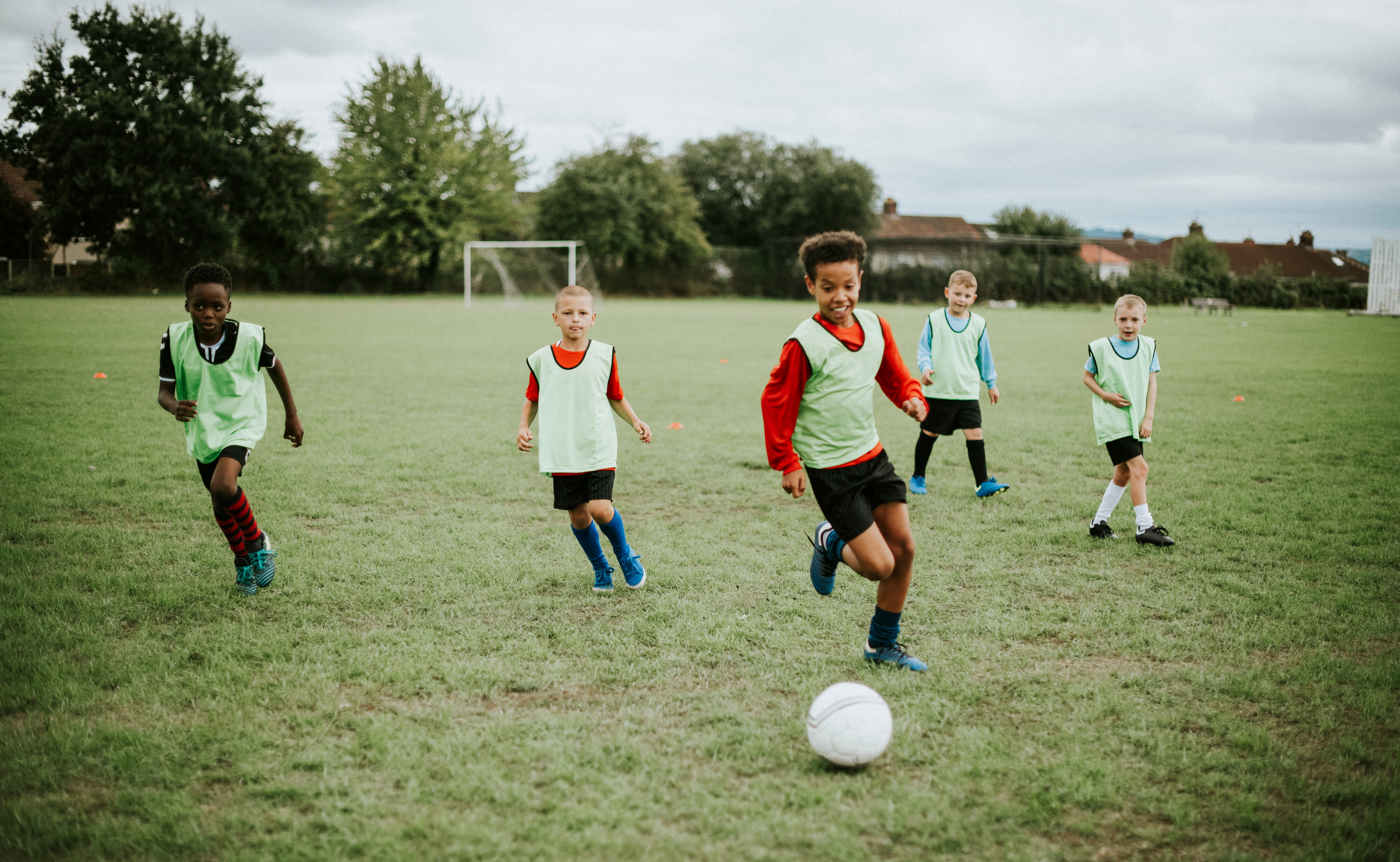 Niños jugando fútbol en un campo de hierba