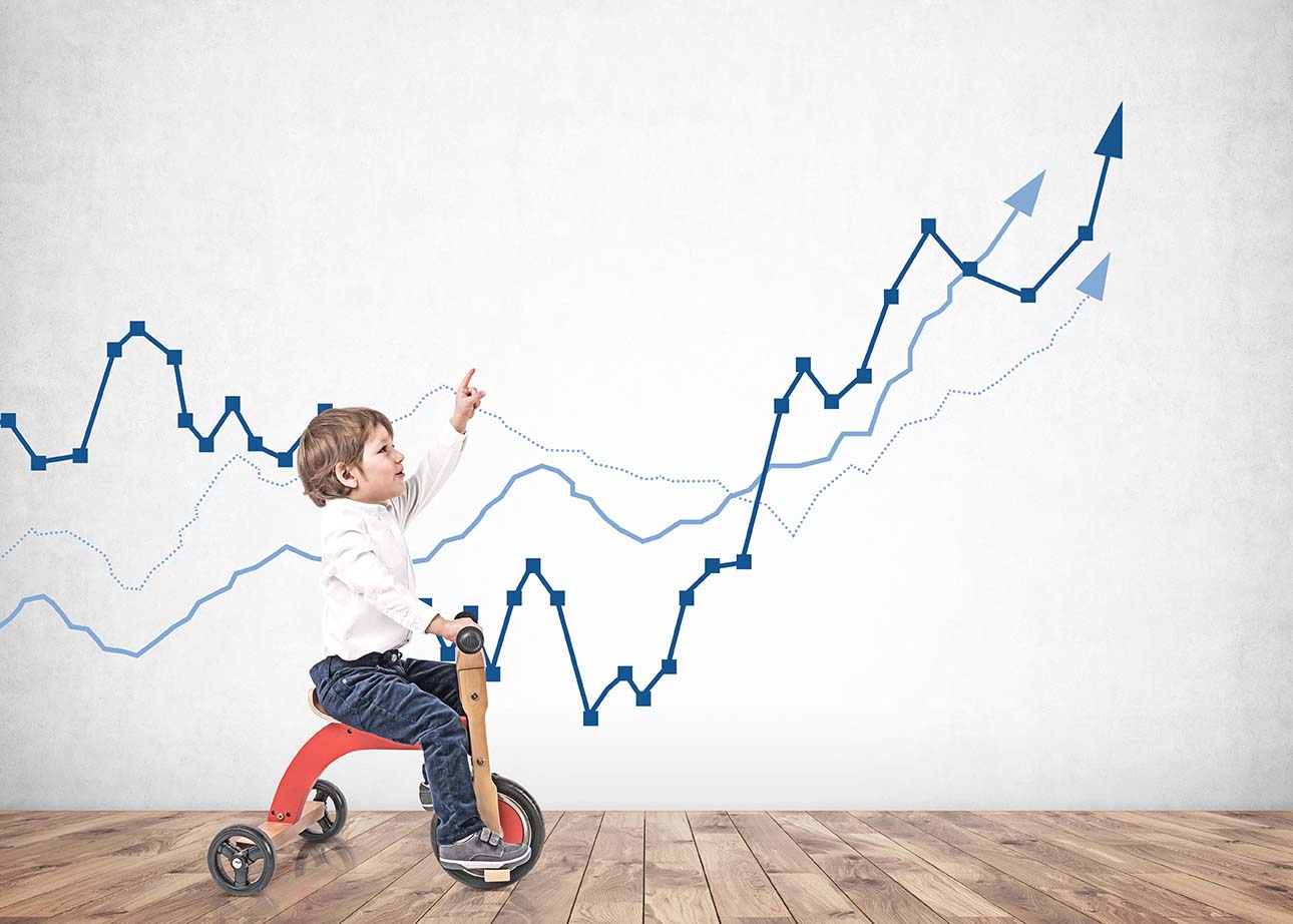 Little boy on tricycle showing growing graph