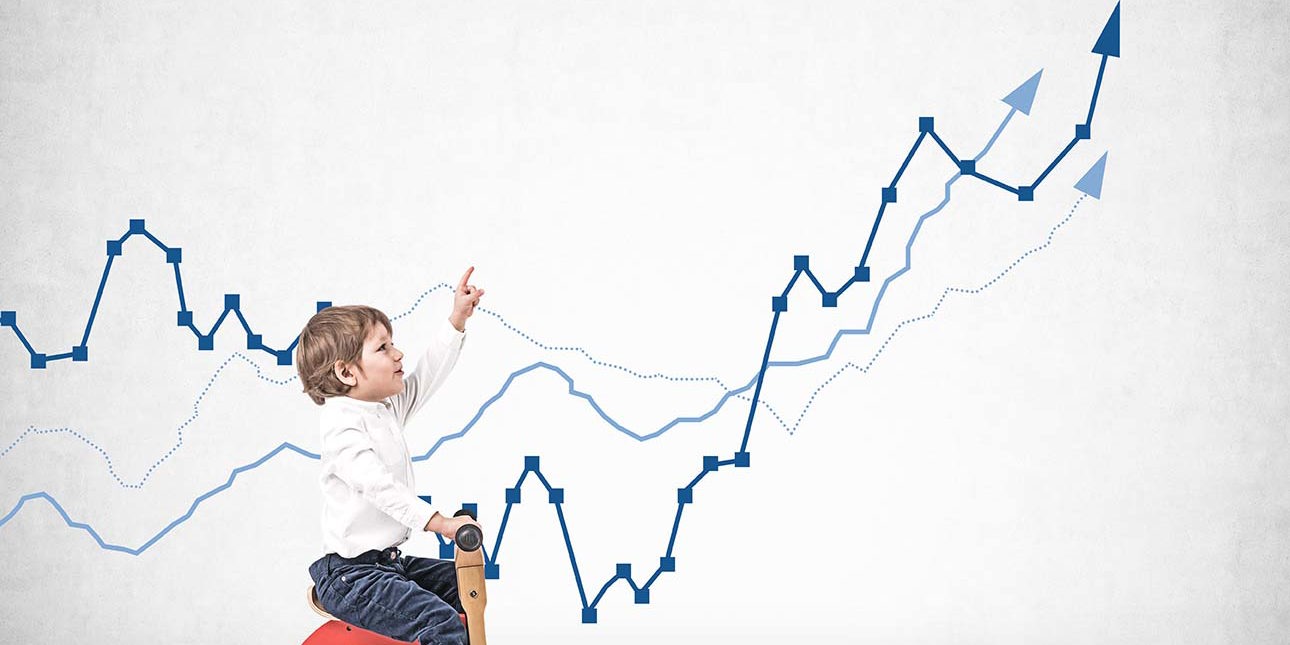 Little boy on tricycle showing growing graph